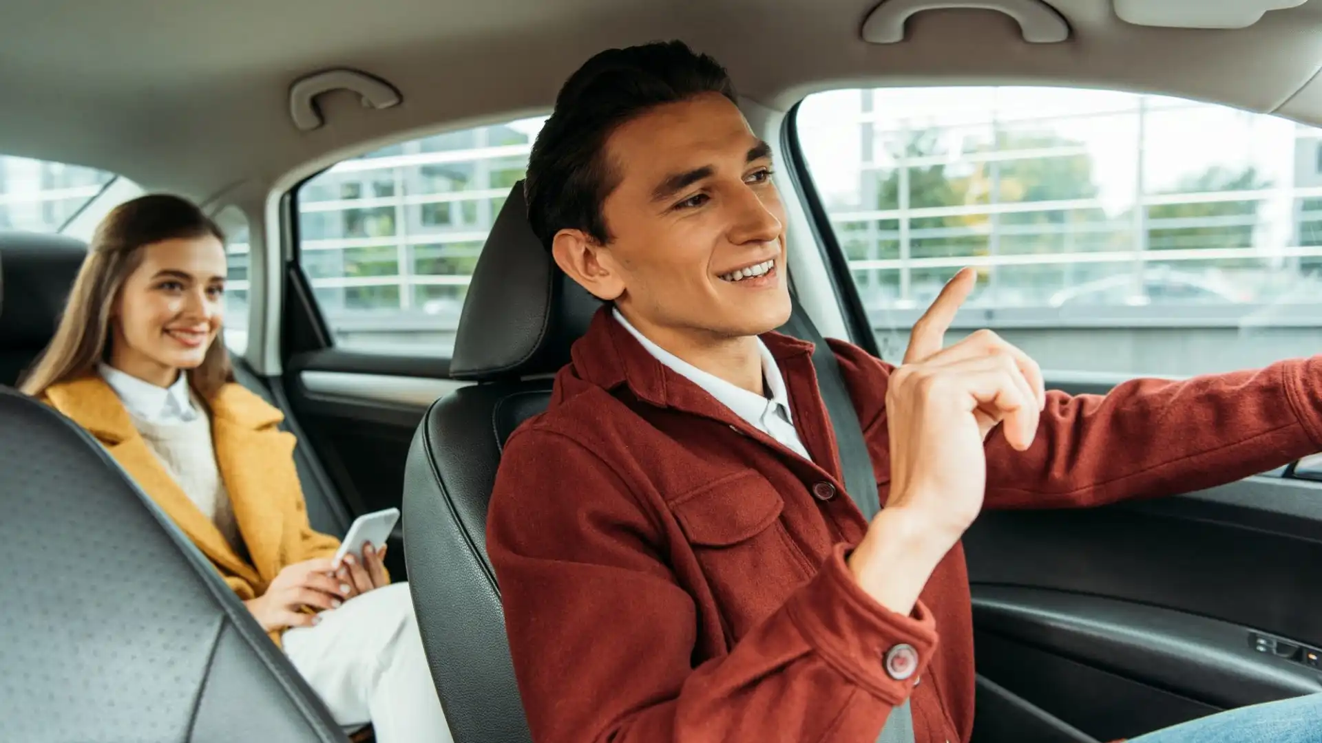 smiling-taxi-driver-and-passenger-with-smartphone